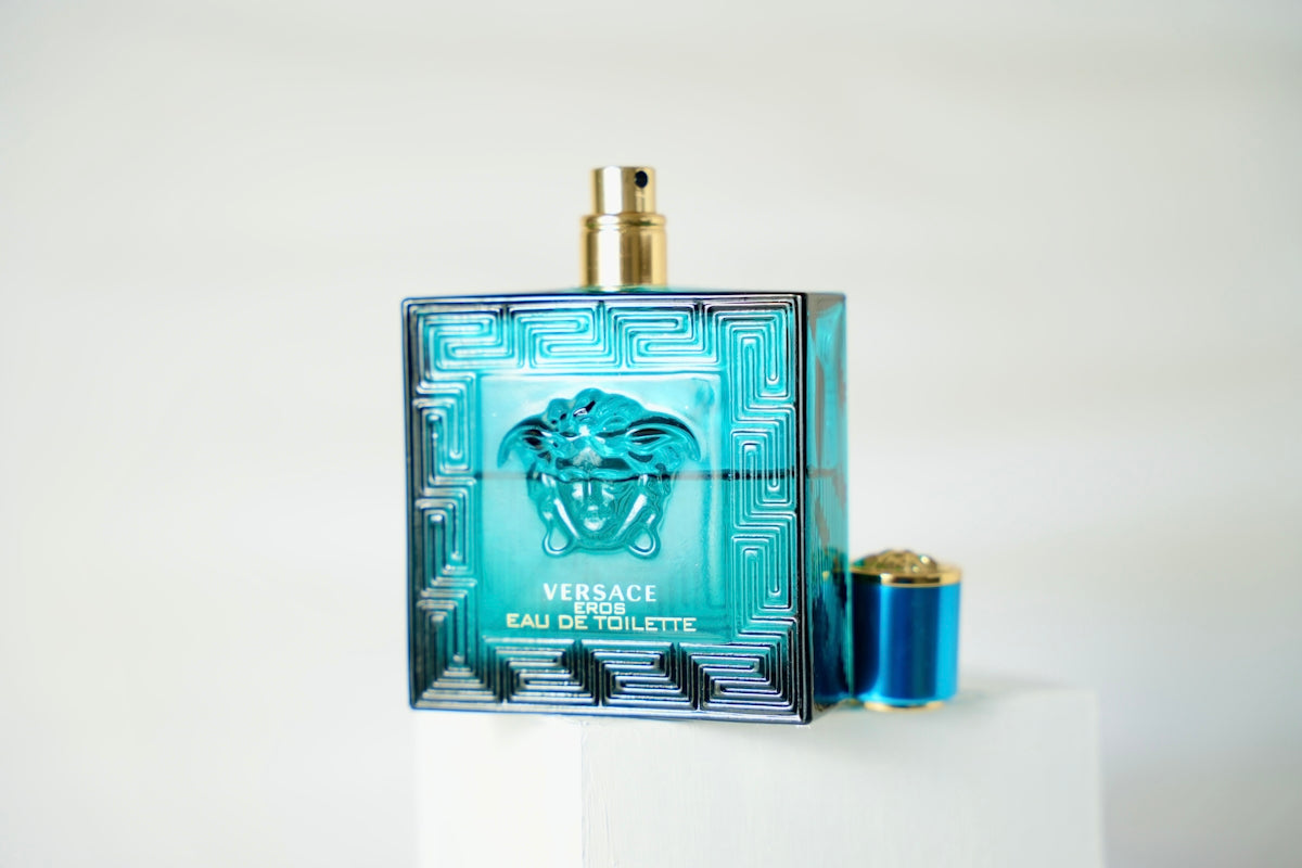 a bottle of perfume sitting on top of a white pedestal